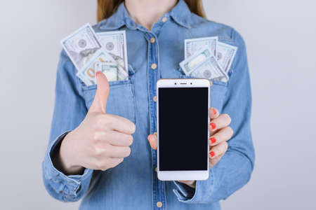 People person okay thumbup choice choose jeans shirt ok jeans student shirt many game customer buyer american concept. Cropped close up photo of lady making money using mobile isolated backgroundの写真素材