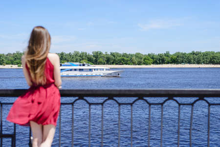 Blue sea sky life sails-man cry day dream sad dreamy lady in red dress concept. Rear back behind...