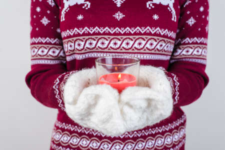 Cropped close up photo portrait of teen child lady holding candle in hands isolated on grey...