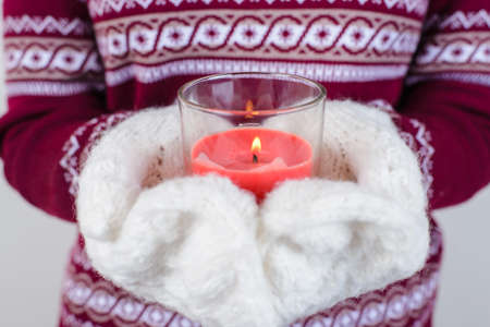Cropped close up photo portrait of teen child lady holding candle in hands isolated on grey backgroundの写真素材