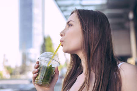Holiday beach beauty teenager model urban stylish cocktail student leisure day concept. Side profile close up view photo portrait of pretty beautiful lady holding transparent cup of syrup in handの写真素材