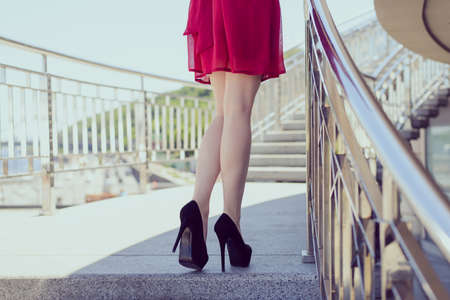 Side walk people person ass buttocks take go run posing concept. Rear back behind close up view photo of sexual tempting seductive ideal perfect fit slim legs, cherry color sarafan, railing balconyの写真素材