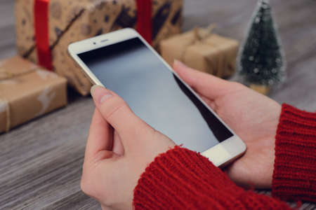Side profile first person view close up photo of hands typing texting writing send notification video call to family via cam over wooden grey tableの写真素材