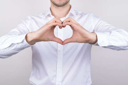 Cropped closeup photo of cheerful handsome nice glad positive guy making heart of two halves isolated grey backgroundの写真素材