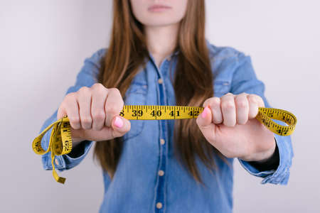 Cropped close up photo of sad unhappy tired exhausted frustrated she her lady showing size of her waist line to camera sad upset unhappy face isolated grey backgroundの写真素材