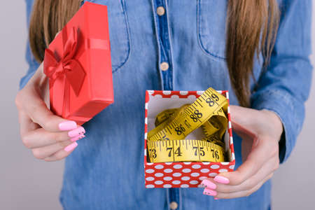 Cropped closeup photo of unhappy shocked amazed sad upset she her lady holding box with tape measure inside she package isolated grey backgroundの写真素材