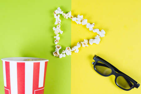 I like love adore watching new film concept. Top above high angle overhead close up view bright photo of play button with tasty popcorn and black 3d glasses isolated over two parts halves backgroundの写真素材