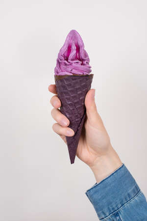 Cropped close up photo of hand showing advertising demonstrating tasty with not classic taste appetizing ice cream isolated grey background jeans denim shirtの写真素材