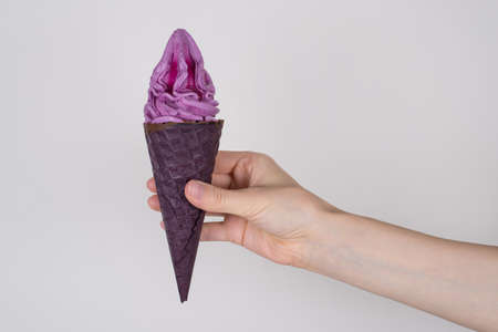 Side profile cropped closeup photo of tasty delicious yummy appetizing ice cream in hand isolated over grey background copy spaceの写真素材