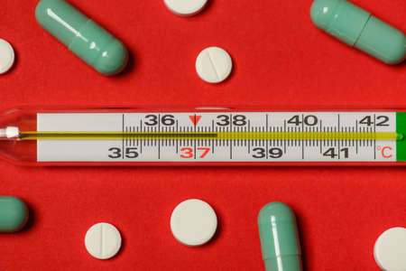 Cropped top above flat lay flatlay close up photo of thermometer with high temperature isolated over red backgroundの写真素材