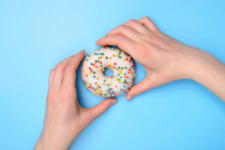 Top above flat lay flatlay overhead close up view photo of hands taking buying tasty fresh sugary donut ready to eat isolated over pastel color table backgroundの写真素材