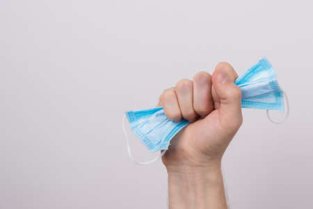 Victory over coronavirus concept. Cropped close up photo of male holding facial medical surgical...