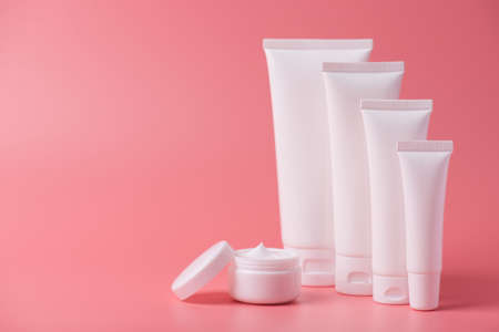 Body pampering advertisement minimal concept. Photo of set of container box creme with open round jar isolated over background with empty spaceの写真素材