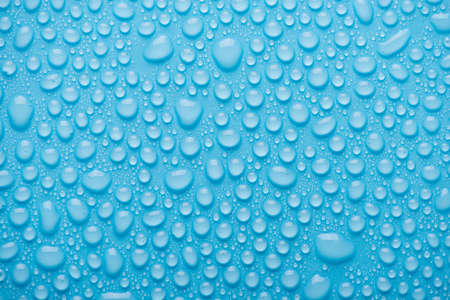Top above overhead view close up photo of bright water drops on the blue backgroundの写真素材