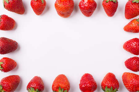 Cropped top above overhead view photo of strawberries lined up on the sides making center empty on white backgroundの写真素材