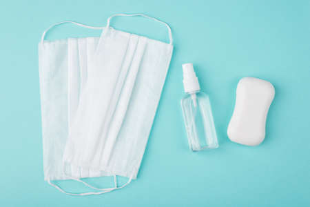 Healthcare during Coronavirus quarantine concept. Top above overhead view photo of masks hand sanitizer bottle and soap isolated on turquoise backgroundの写真素材