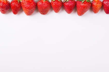 Cropped top above overhead view photo of strawberries lined up from above on white background