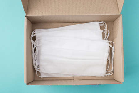 Coronavirus prevention concept. Top above overhead view photo of a box full of masks isolated on turquoise backgroundの写真素材