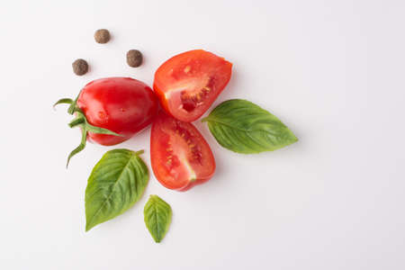 Organic food eating concept. Top above overhead view photo of tomatoes spices and baby spinach isolated on white backgroundの写真素材