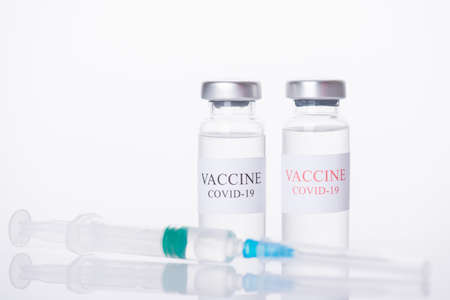 Immunization and COVID-19 treatment concept. Close-up photo of two COVID-19 vaccine vials and shot...