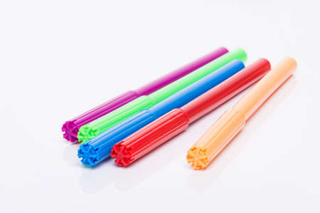 Coloring with markers concept. Photo of multicolored markers with caps on isolated white background