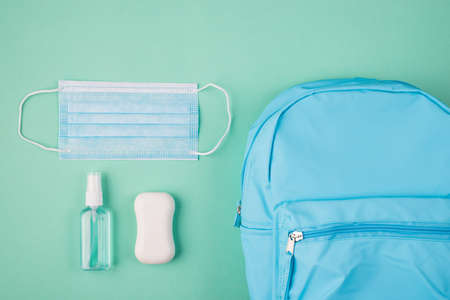 Coronavirus outbreak concept. Healthcare concept. Top above overhead view photo of blue backpack mask soap and hand sanitizer isolated on turquoise backgroundの写真素材