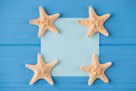 Top above overhead view close-up photo of a blank note with starfish isolated on blue wooden background with copyspaceの写真素材