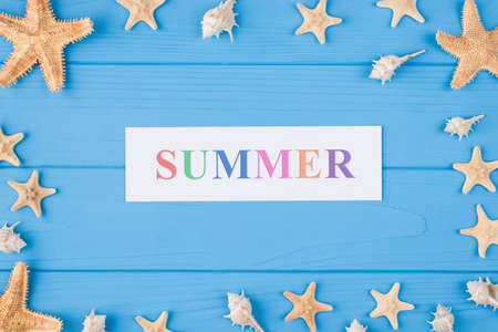 Summer vacation concept. Top above overhead view photo of word summer and seashells and seafish isolated on blue wooden backgroundの写真素材