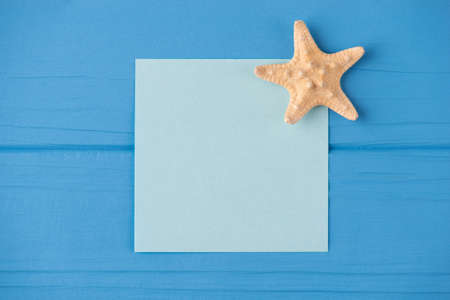 Top above overhead view close-up photo of a blank note with a small starfish isolated on blue wooden background with copyspaceの写真素材