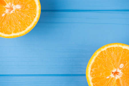Top above overhead view cropped photo of two orange slices isolated on blue wooden background with copyspaceの写真素材