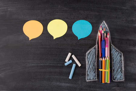 Photo of drawn rocket with colorful pencilc and pens chalk and three stickers isolated on classroom blackboard with copyspaceの写真素材