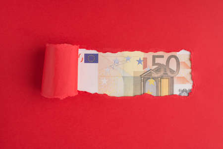 Top above overhead view photo of torn red paper over 50 euro bill with copyspace