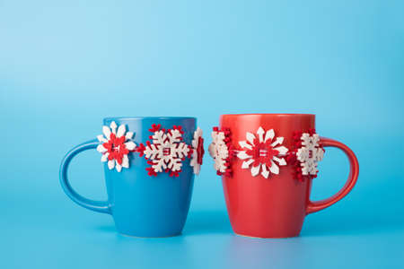 Close up photo of blue and red decorated coffee cups isolated on blue background with copyspaceの写真素材