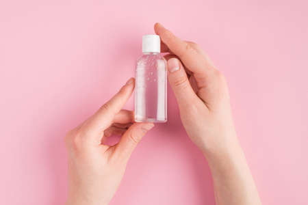 Top above overhead close up pov first person view photo of female holding gel sanitizer isolated on pink pastel background with copyspaceの写真素材