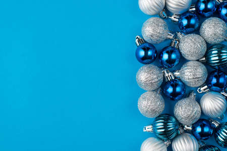 Christmas is coming soon concept. Top above overhead view close up photo of beautifully decorated blue baubles placed to the right side isolated on blue background with copyspaceの写真素材