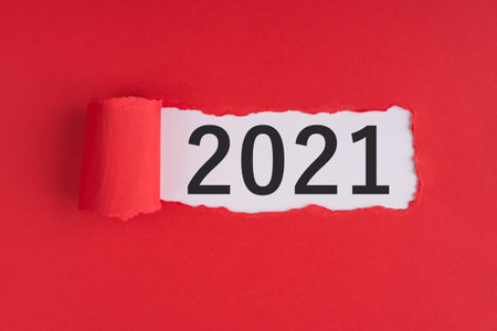 Photo of torn red paper with 2021 text inside over white background with copyspaceの写真素材