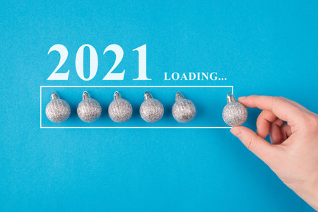 Christmas is coming concept. Top pov close up view photo of female hand putting toy shiny ball in a row isolated blue backgroundの写真素材