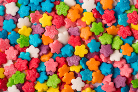 Close-up top view photo of small little shiny colorful mini flowers sugar icing textured background