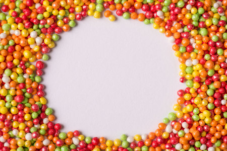 Close-up photo of bright vivid vibrant multicolored background of sugar sprinkles with clear copy space in center for text or designの写真素材
