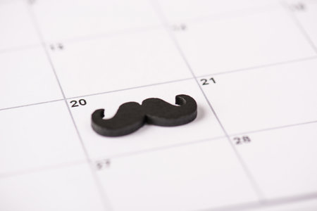 Happy Father's day concept. Close up photo of black mustache marked lying on calendar cellの写真素材