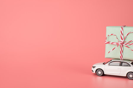 happy women's day concept. Side profile close up view photo of white mini modern car carrying big parcel on top roof isolated light pastel color background with empty blank spaceの写真素材