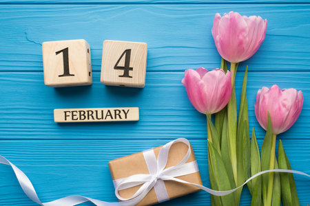 Happy st valentine day concept. Flat lay close up top above overhead view photo picture of tender tulips with ribbon and wooden cube calendar on bright wooden deskの写真素材