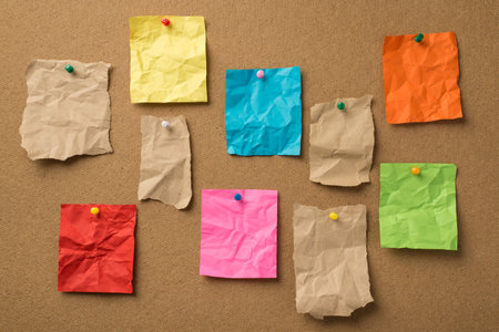 Photo of different colorful and kraft crumpled paper with place for text attached with multicolored...
