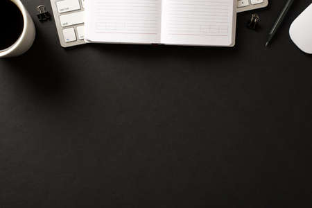 Above overhead view photo of keyboard mug with beverage wooden pencil mouse open copybook isolated black backdrop with blank space belowの写真素材