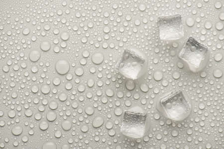 Top overhead above view photo image of ice cubes with rain drops on gray backdrop