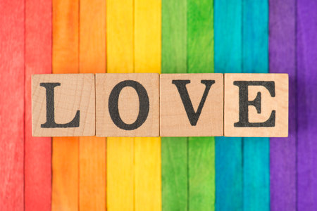 Close up photo image of wooden blocks with love text isolated multicolored deskの写真素材