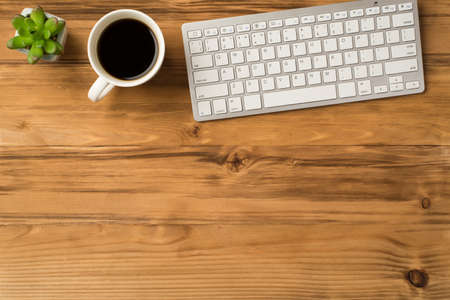 Overhead above close up view photo picture of computer keyboard cup of espresso and green succulent isolated brown backdropの写真素材