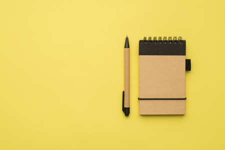 Photo overhead organic notebook and pen isolated on the yellow background