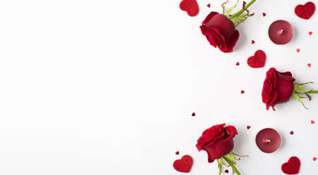 Photo overhead of roses hearts confetti and candles isolated on the white backgroundの写真素材