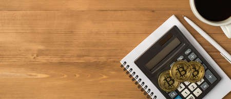 Top view photo of workplace with pen cup of coffee three gold coins with bitcoin symbol and...